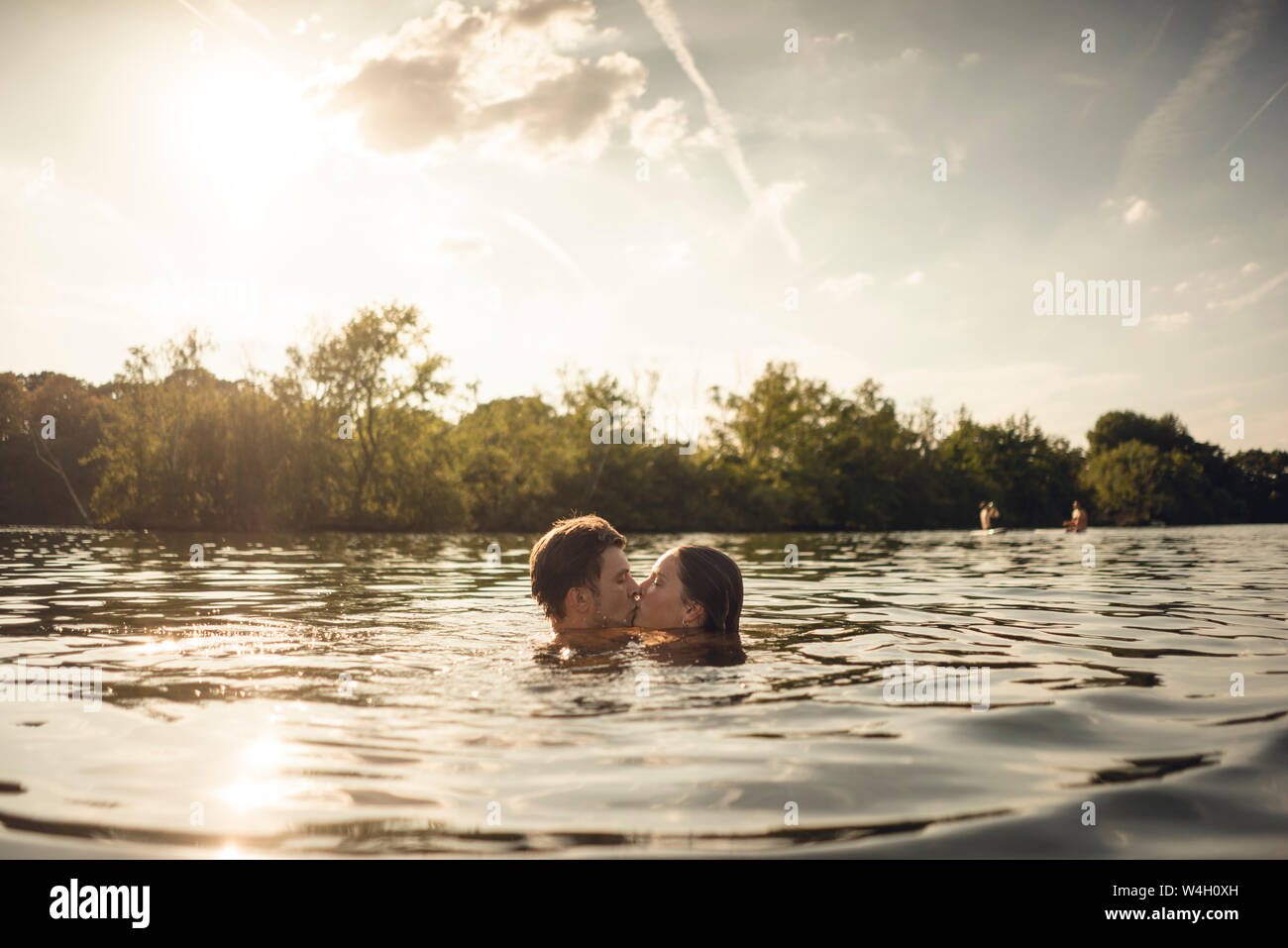 Affectionate couple nageant ensemble dans un lac Banque D'Images