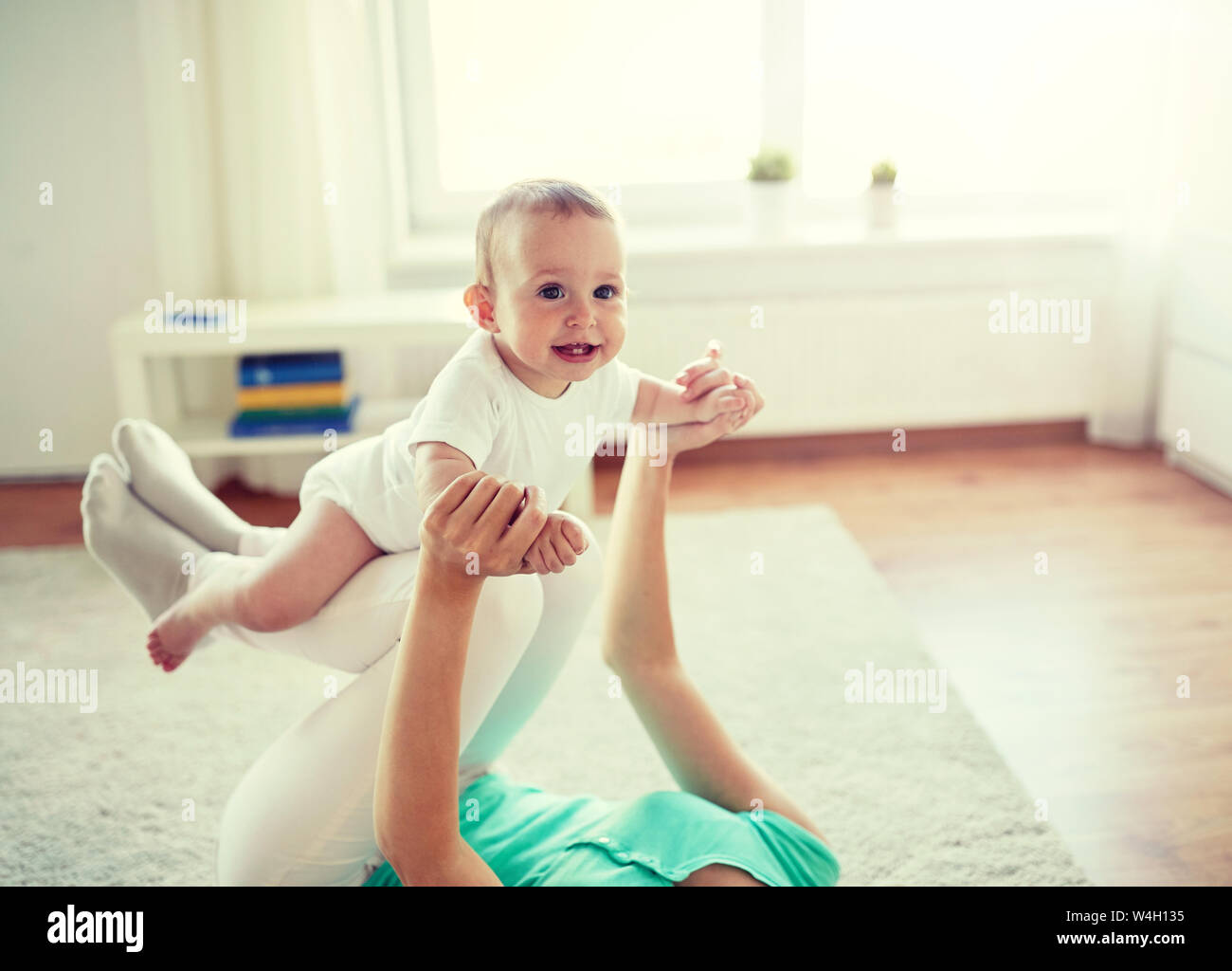 Mère heureuse de jouer avec bébé à la maison Banque D'Images