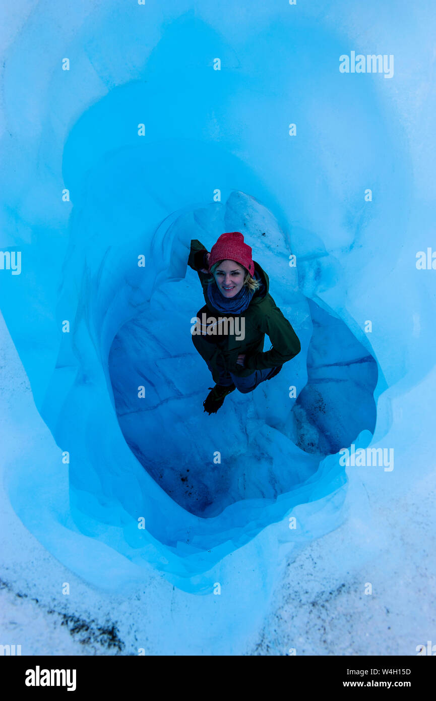 Femme debout dans une grotte de glace, Fox Glacier, île du Sud, Nouvelle-Zélande Banque D'Images