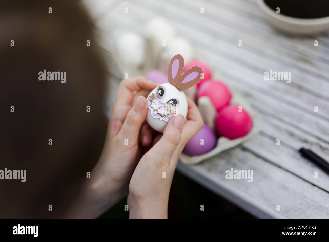 Close-up of girl decorating easter egg sur table de jardin Banque D'Images