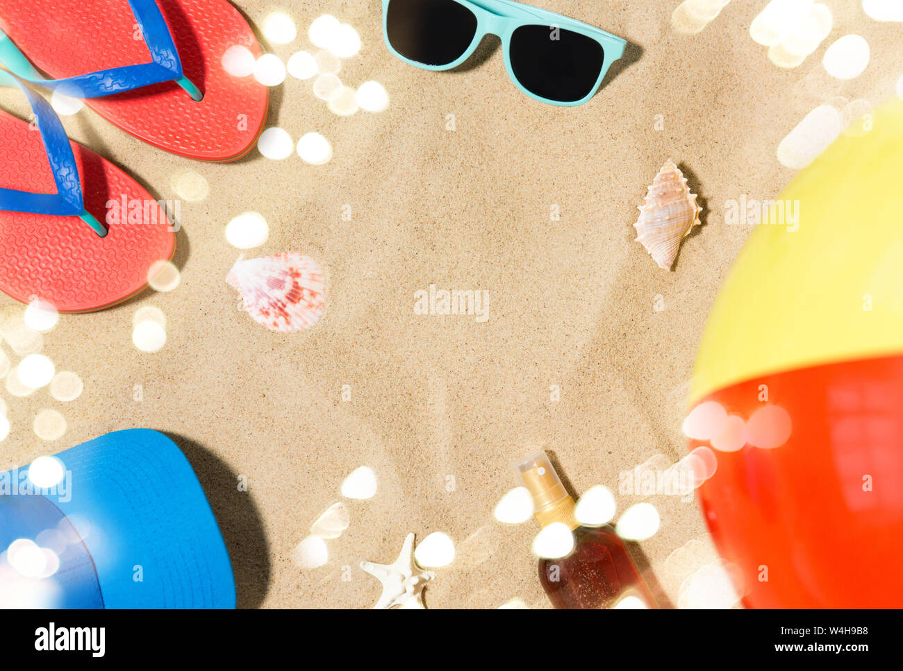 Cap, tongs et de nuances et de ballons de plage sur le sable Banque D'Images