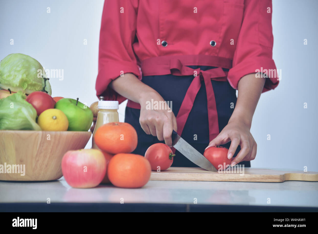 Jolie asiatique charmante femme chef préparer des aliments styliste. Cuisine saine.chef de cuisine uniforme Banque D'Images