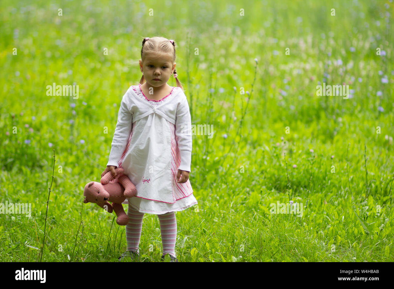 Triste enfant seul avec toy debout dans le parc d'été Banque D'Images