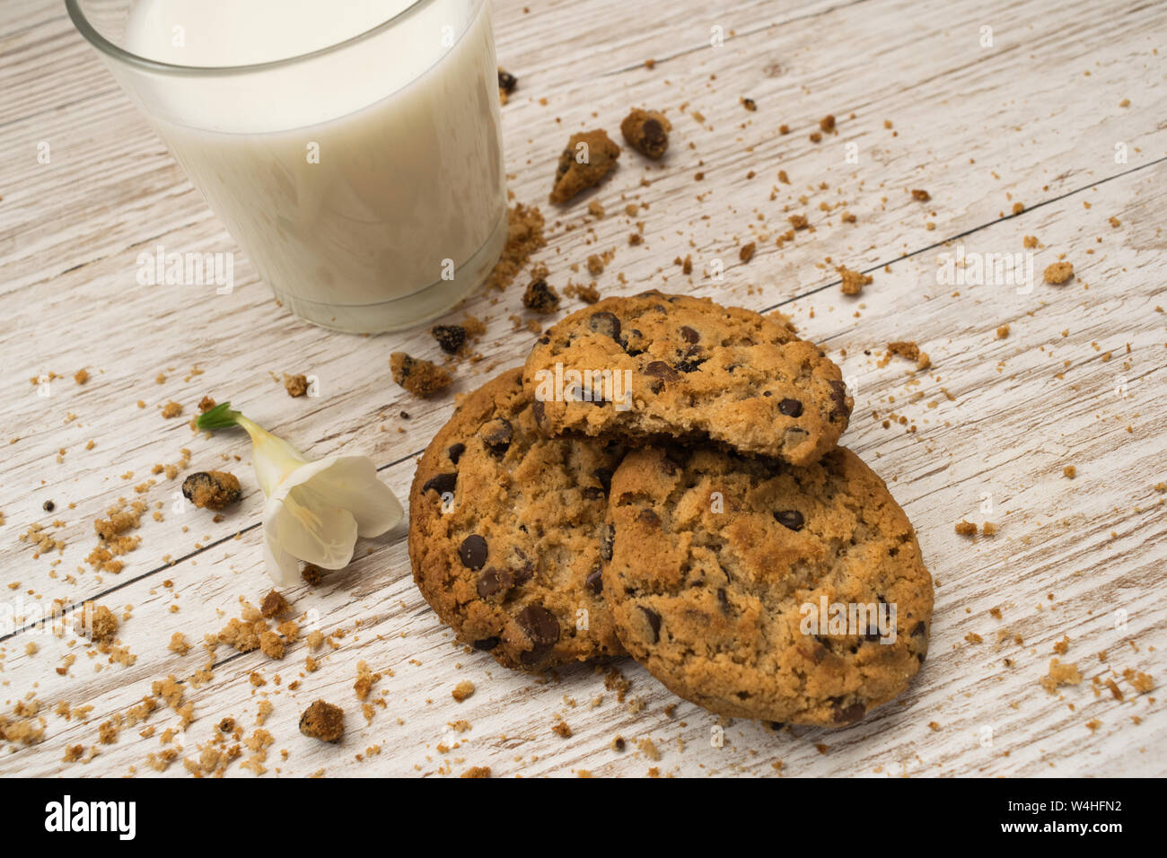 Vue de dessus de cookies aux pépites de chocolat, miettes et un verre de lait sur une table en bois Banque D'Images