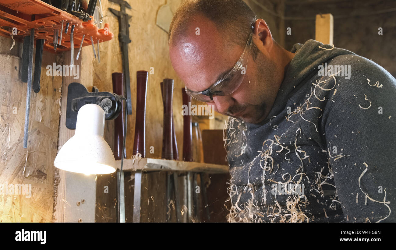 Portrait de l'homme au travail libre. Artisan travaille avec bois en atelier. Carpenter couvert de sciure et de rasage. Banque D'Images