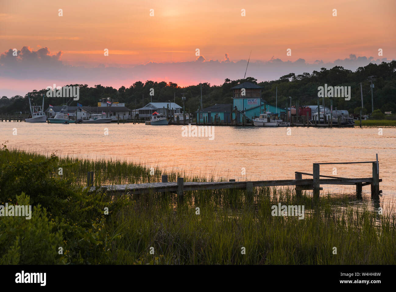 Coucher de soleil sur le chenal avec les bateaux de pêche et les quais, Holden Beach, North Carolina Banque D'Images