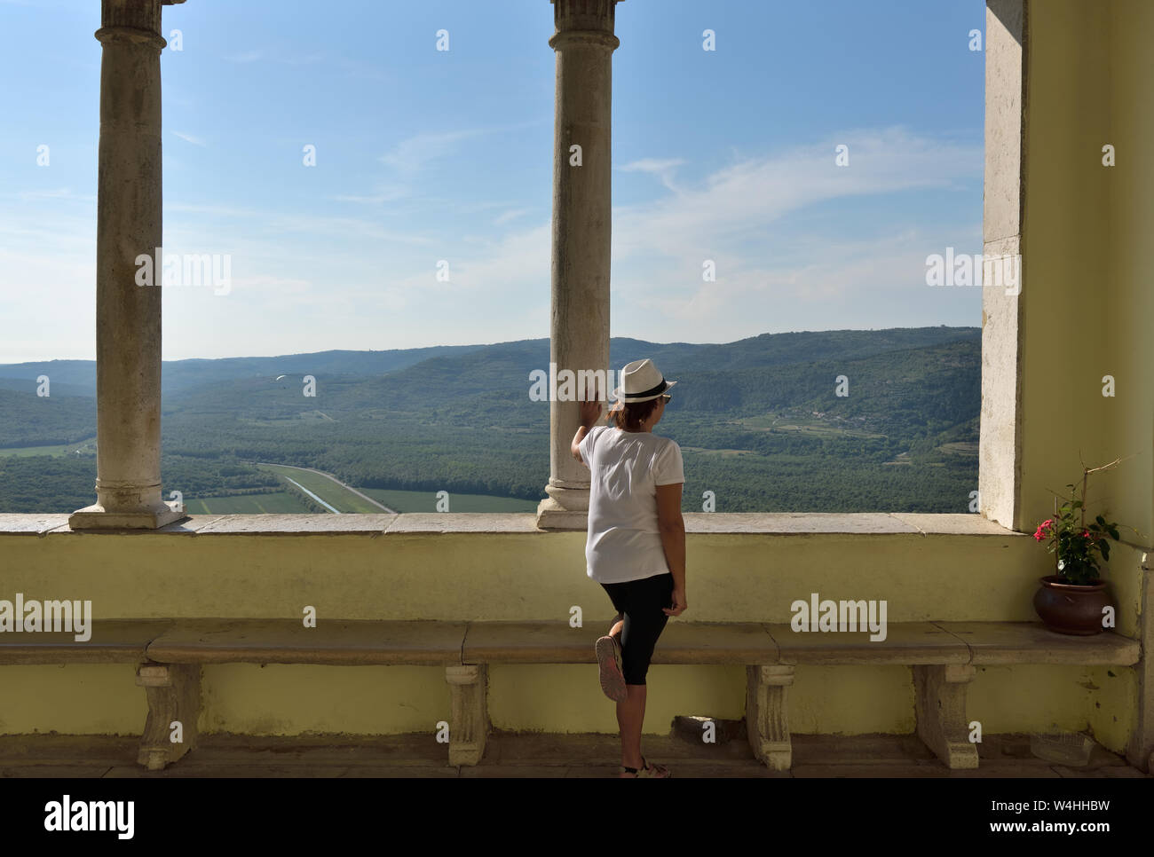 Une dame en chapeau blanc regardant un large panorama Banque D'Images