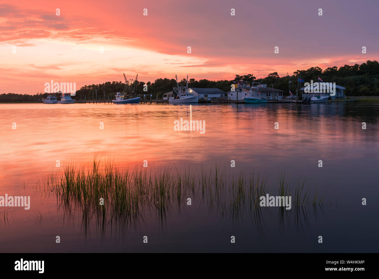 Coucher de soleil sur le chenal avec les bateaux de pêche et les quais, Holden Beach, North Carolina Banque D'Images