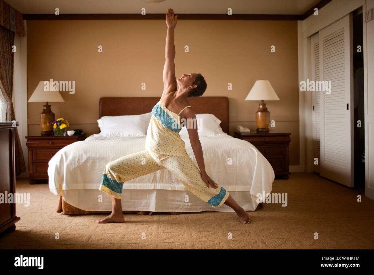 Young woman doing yoga dans la chambre Banque D'Images