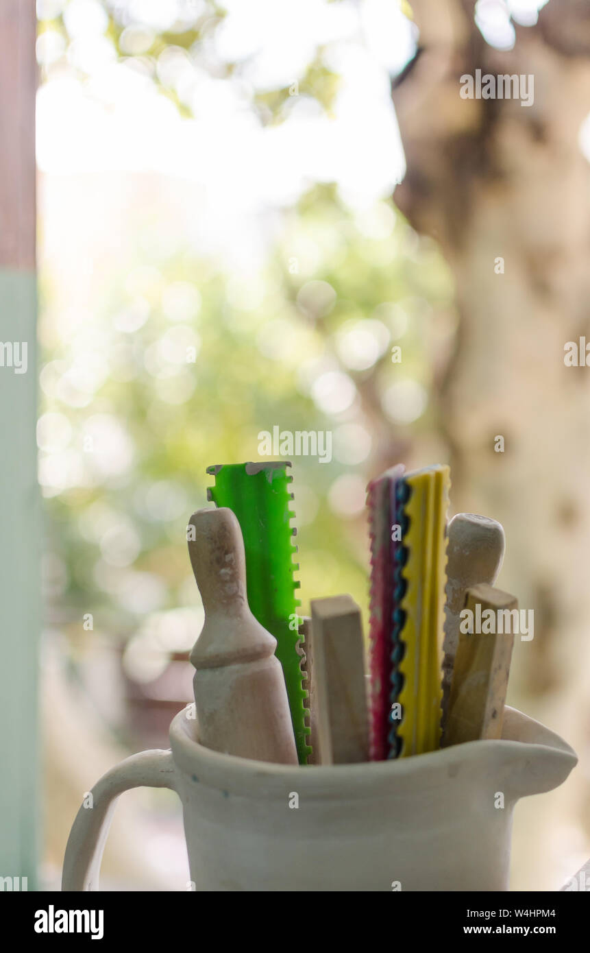 Vue verticale de divers outils en bois Poterie près d'une fenêtre sur un matin ensoleillé. Concept connexes poterie Banque D'Images