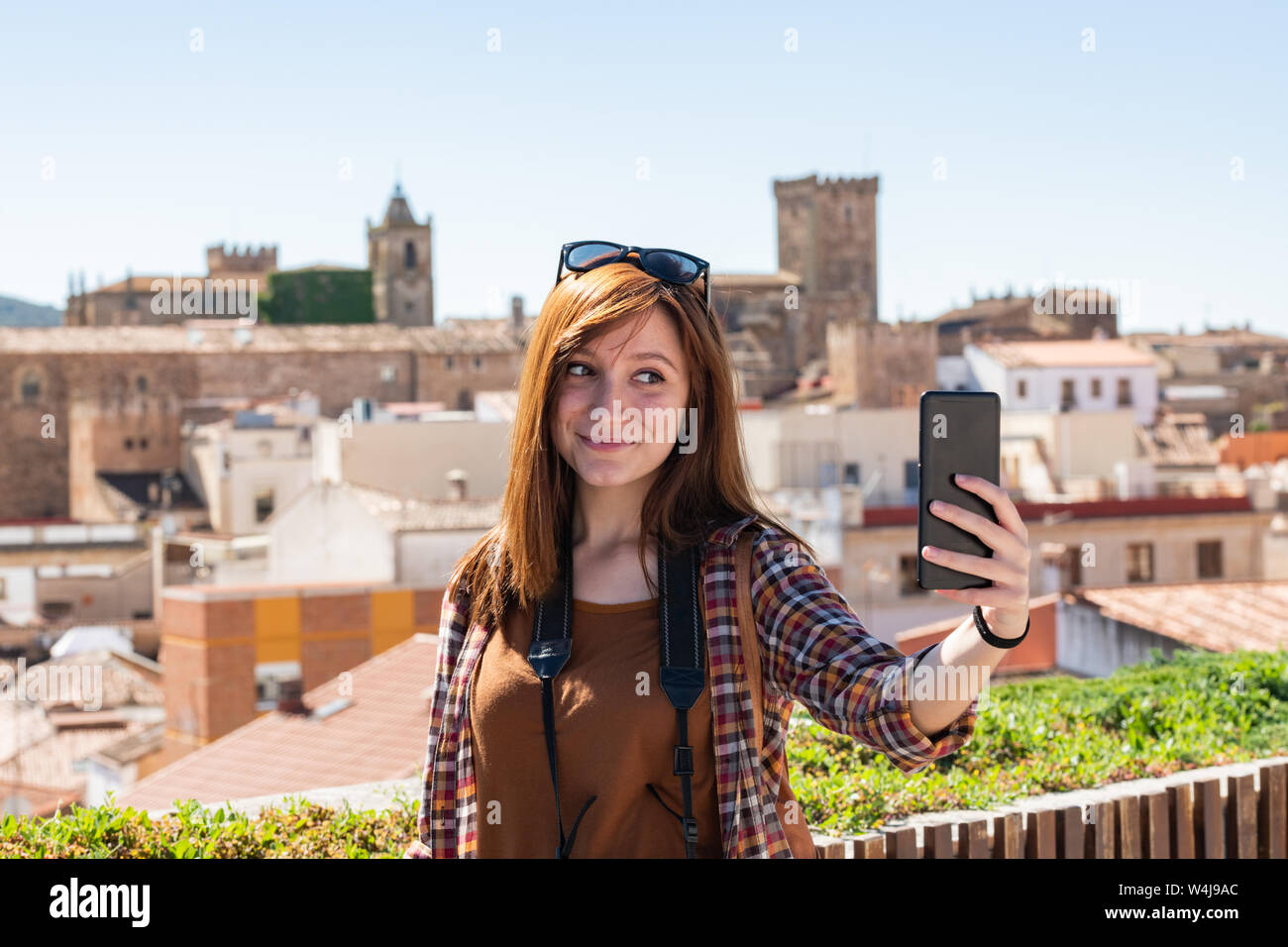 Une jeune touriste rousse fait un du point de vue des selfies Galarza avec la vieille ville de Caceres en arrière-plan Banque D'Images