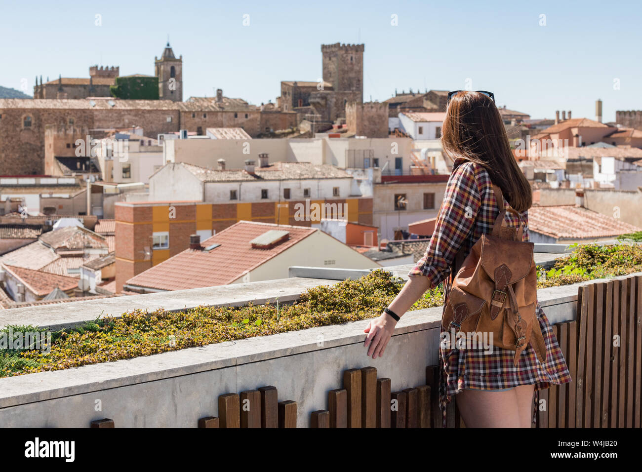 Une jeune touriste rousse avec un sac à dos observe la vieille ville de Caceres du point de vue de Galarza Banque D'Images