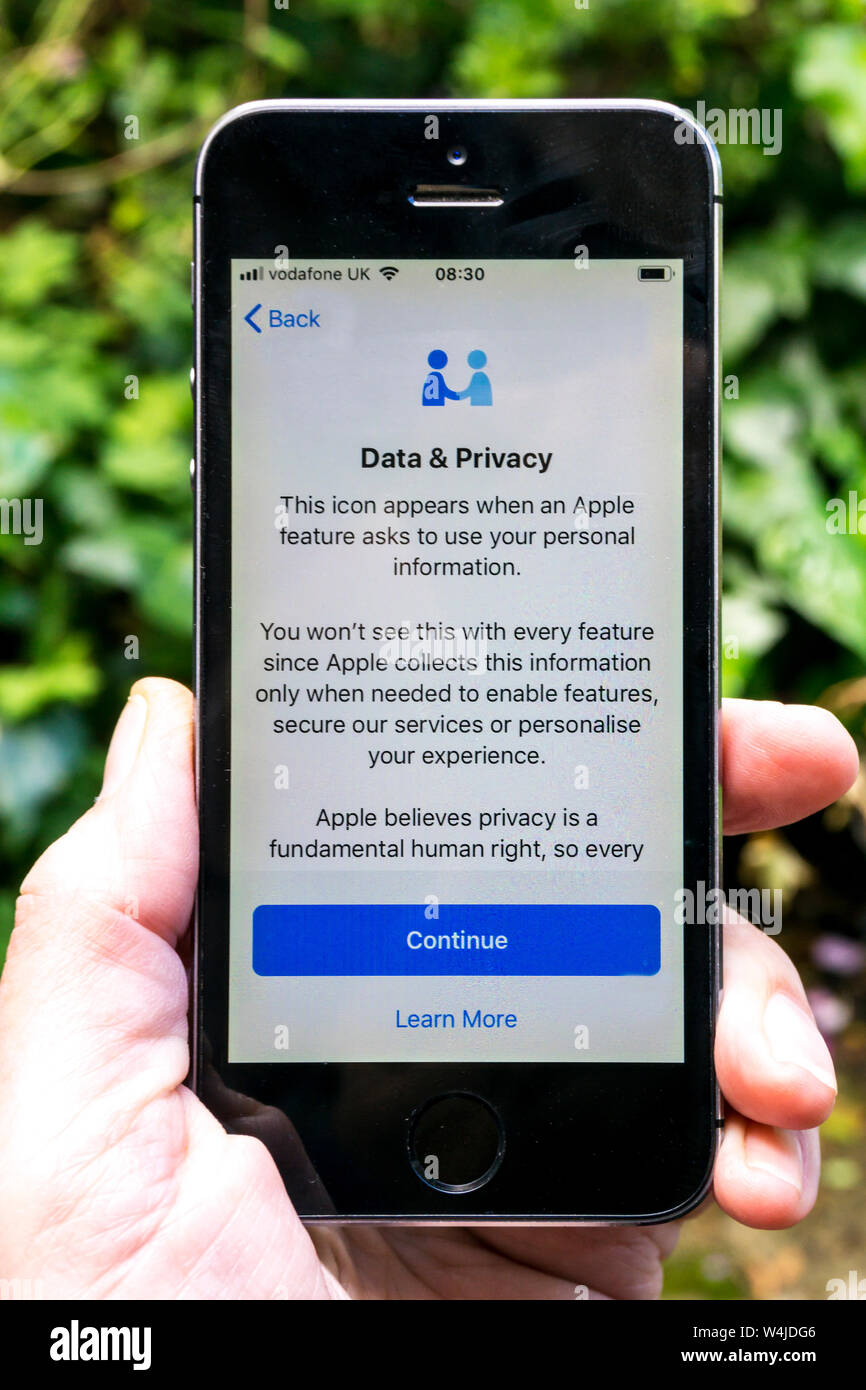 Personne titulaire d'un Apple iphone affichant un message sur l'icône Données et confidentialité. Banque D'Images