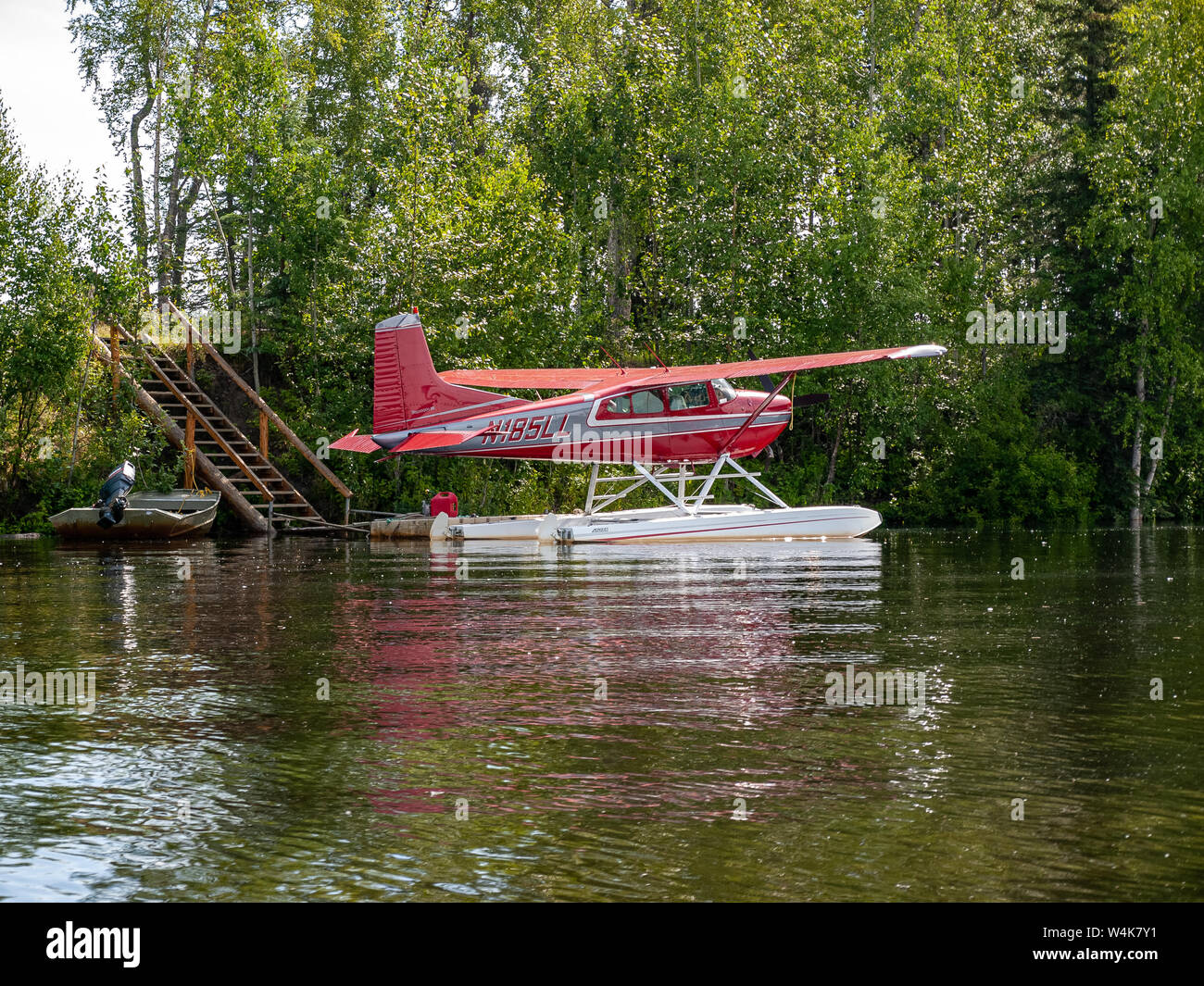 Cessna 185 avion flottant sur Alexander Creek. Alaska. Nord-Ouest d'Anchorage, Alaska. Près de la rivière Susitna. Chien sur le quai. N185 LL Banque D'Images