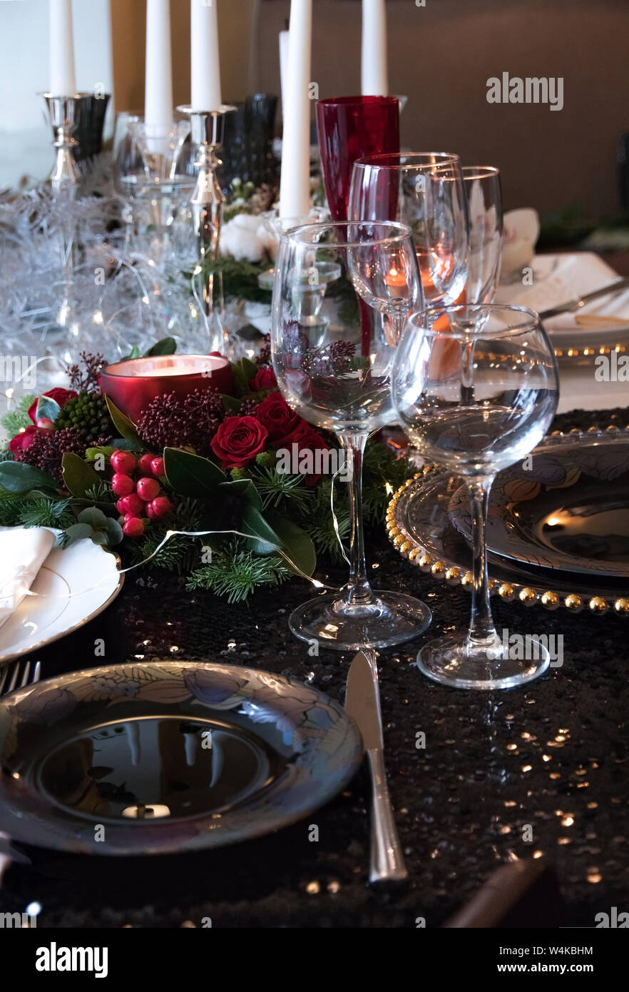 Composition de Noël branches de sapin, des baies et des bougies sur la  table. Réglage de la table de fête pour le dîner de Noël sur une nappe noire  brillante et ex