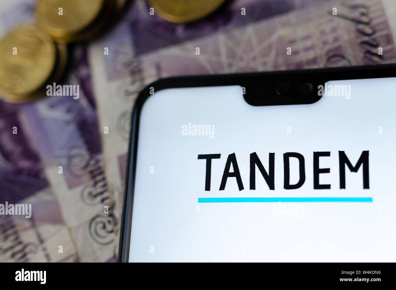 Banque Tandem app sur l'écran du smartphone avec l'argent flou sur l'arrière-plan. Banque D'Images