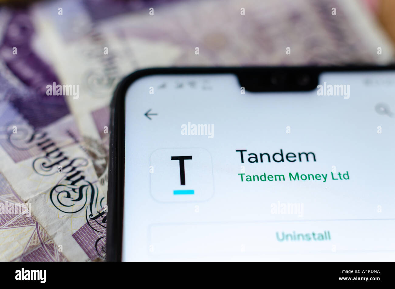 Banque Tandem app sur l'écran du smartphone avec l'argent flou sur l'arrière-plan. Banque D'Images