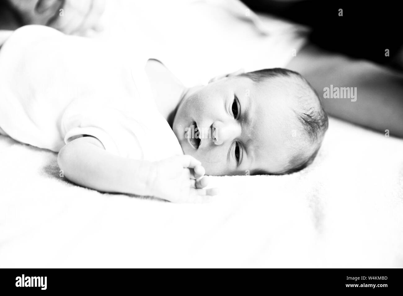 Le noir et blanc photo dans le style rétro : un portrait de nouveau-né avec mère portant sur le lit. Banque D'Images