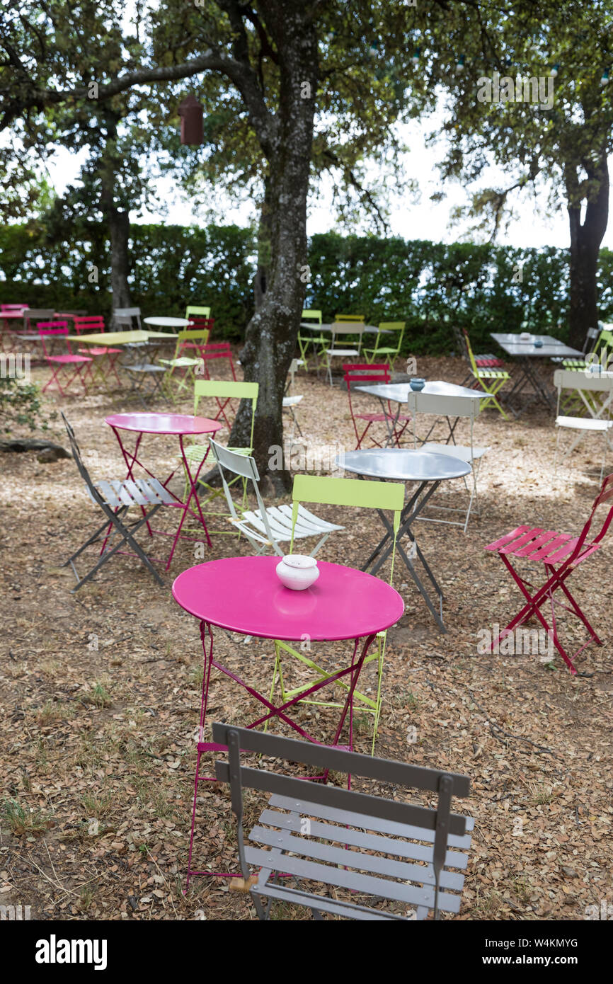 Café coloré des tables et des chaises dans le jardin ombragé Banque D'Images