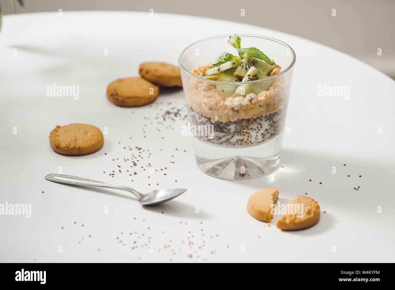 Prêt à manger sain un petit déjeuner nutritif - Granola aux amandes, graines de chia, banane et kiwi fruits et de baies et d'un bocal avec du lait à proximité Banque D'Images