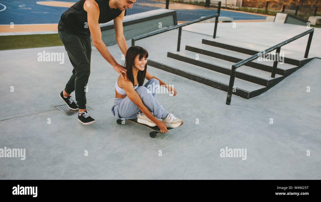 Deux jeunes amis s'amusant à skate park. Couple enjoying skateboarding en plein air au skate park. Banque D'Images