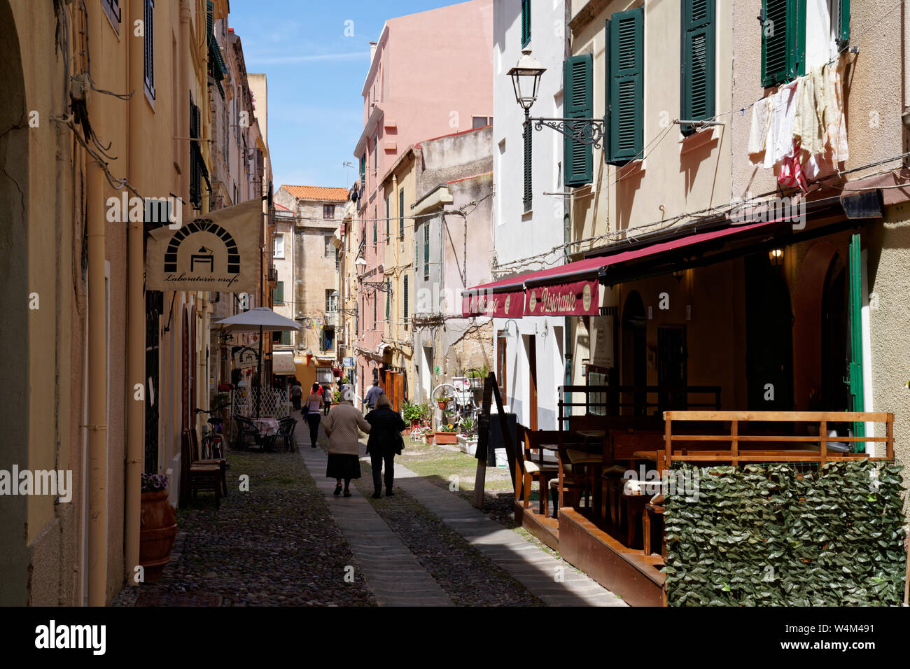 Les femmes âgées de derrière, se promenant dans une rue de côté trottoir dans Alghero, Sardaigne Banque D'Images