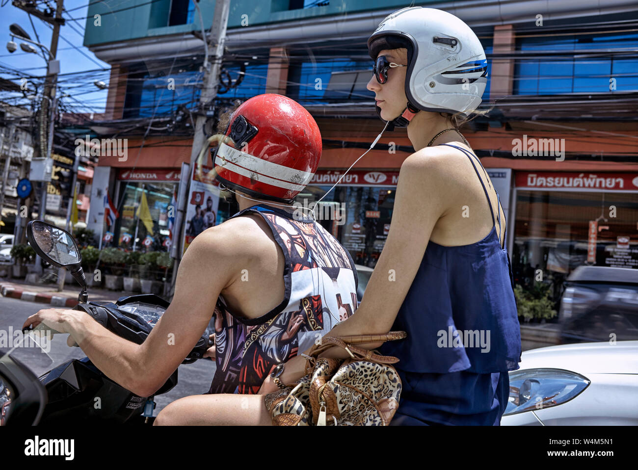 Moto femme. Une femme qui monte sur une moto et partage de musique depuis  son smartphone, via un casque, avec le cavalier masculin Photo Stock - Alamy