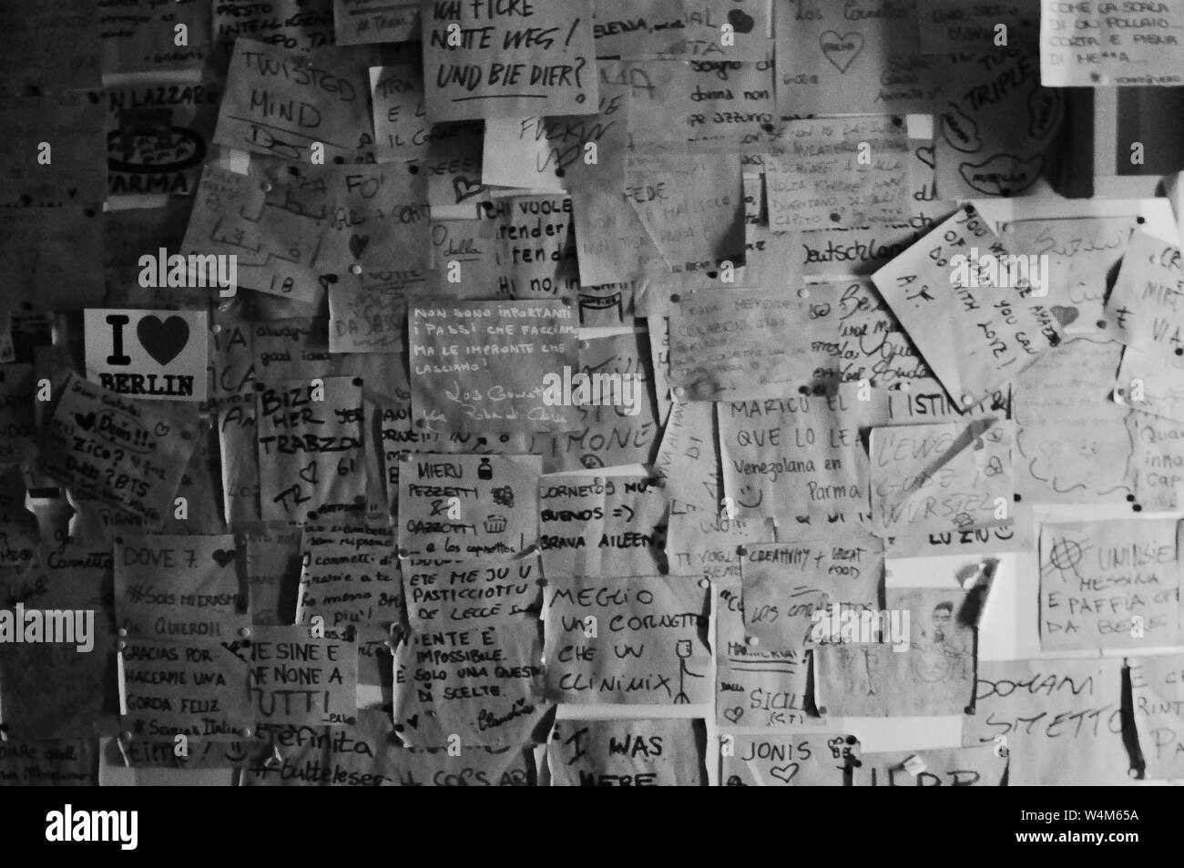 Photo en noir et blanc d'un mur entièrement recouvert notes adhésives en italien Banque D'Images