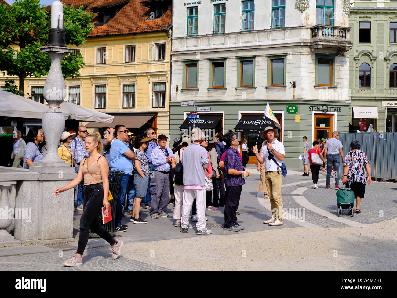 Ljubljana, Slovénie, le 18 juin 2019. Guide touristique avec un drapeau à la tête d'un groupe d'asiatiques à travers la vieille ville de Ljubljana Banque D'Images