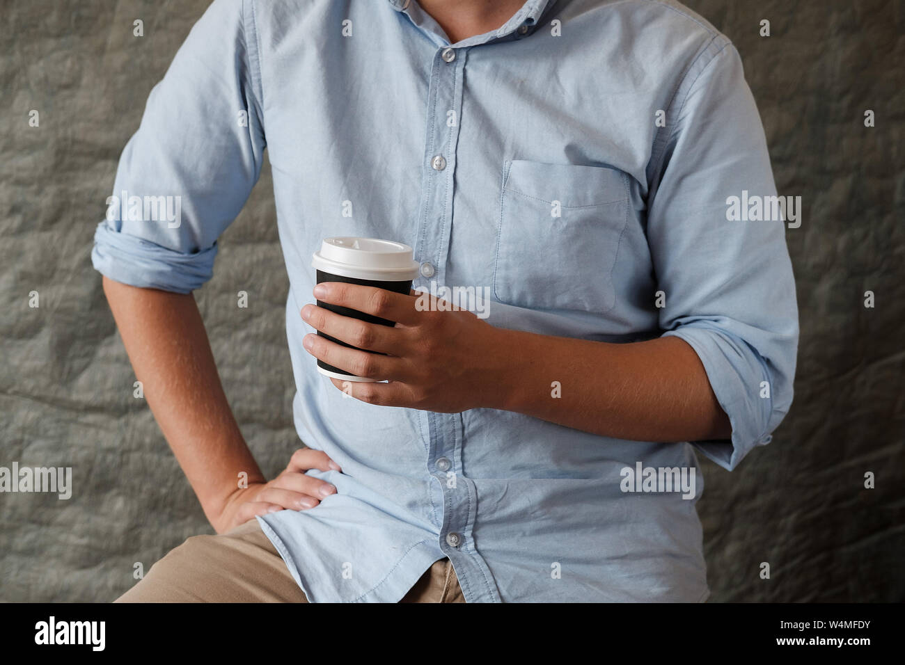 L'homme en chemise bleue holding tasse de café. Les mains des hommes avec une tasse de thé. Close up Banque D'Images
