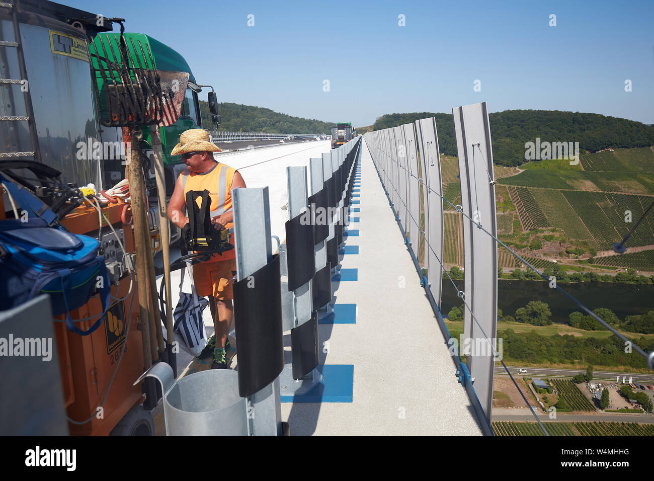 Zeltingen Rachtig, Allemagne. 24 juillet, 2019. La surface de la route d'asphalte les travailleurs de l'Hochmosel bridge en construction à des températures bien au-dessus de 30 degrés Celsius. Il n'est pas ombragée sur les 160 mètres de haut au-dessus de la vallée de la Moselle. Crédit : Thomas Frey/dpa/Alamy Live News Banque D'Images