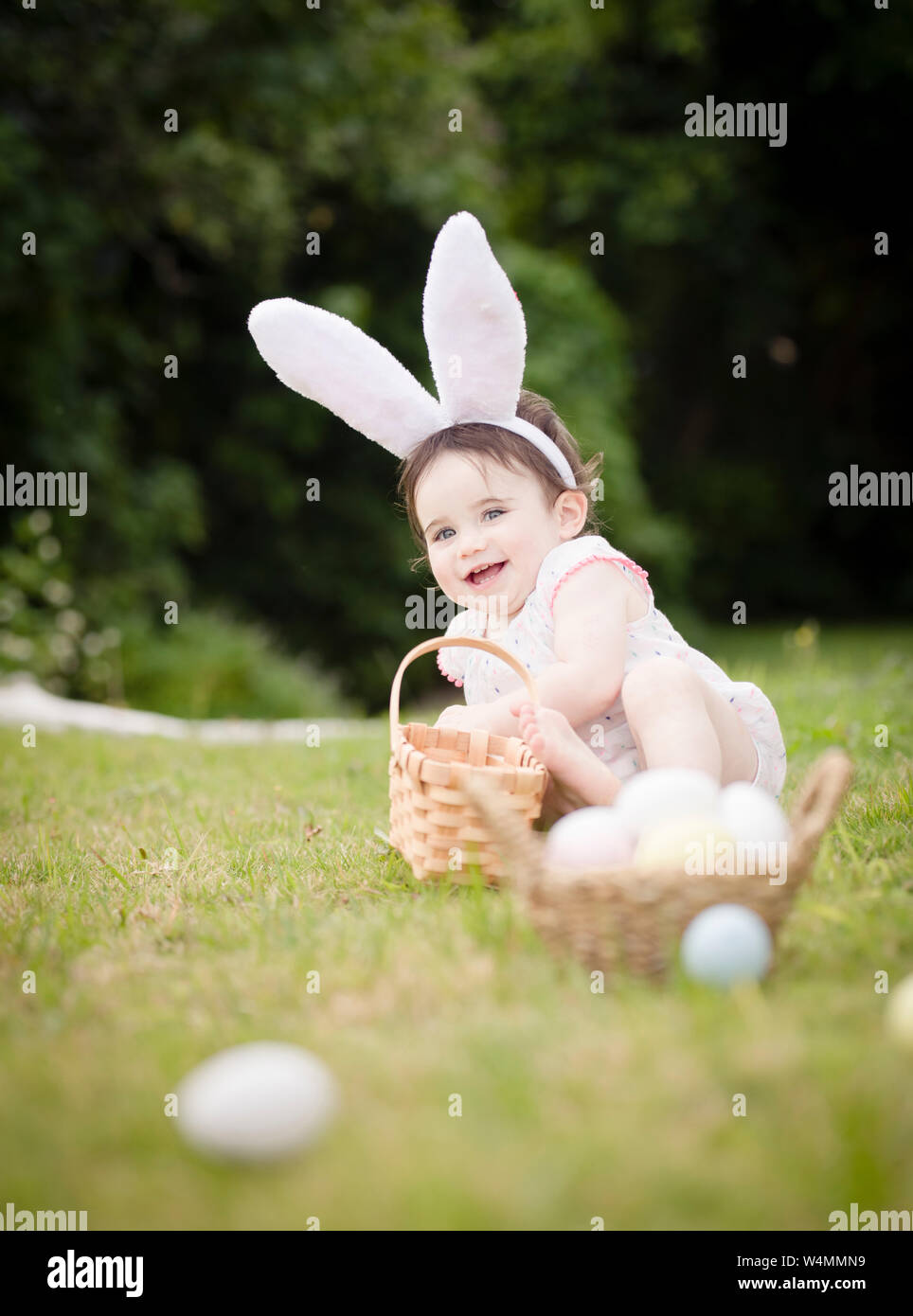 1 ans tout-petit en costume de lapin de Pâques ramasser des œufs à l'extérieur Banque D'Images