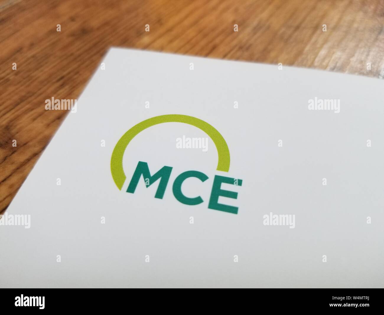 Close-up de logo pour l'énergie renouvelable en Californie MCE fournisseur sur un papier blanc contre une surface en bois clair, le 7 juillet 2019. () Banque D'Images