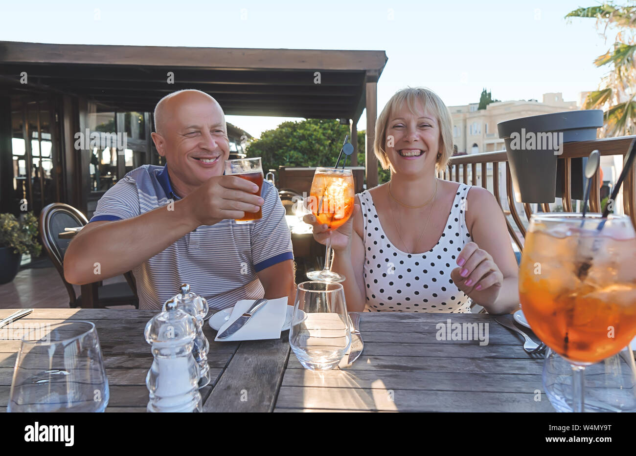Couple de baby-boomers personnes souriantes et profiter d'un verre au restaurant sur soirée d'été ensoleillé Banque D'Images