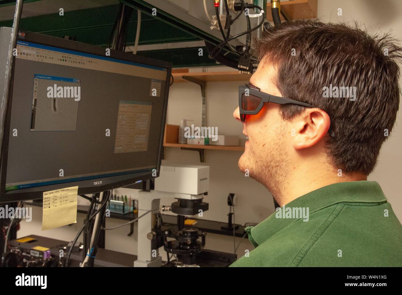 Portrait de profil d'un chercheur dans le département de biophysique Jenkins à l'Université Johns Hopkins de Baltimore (Maryland), le port de lunettes de protection lors de l'affichage d'une image sur un écran d'ordinateur, le 22 juillet 2008. À partir de la collection photographique de Homewood. () Banque D'Images