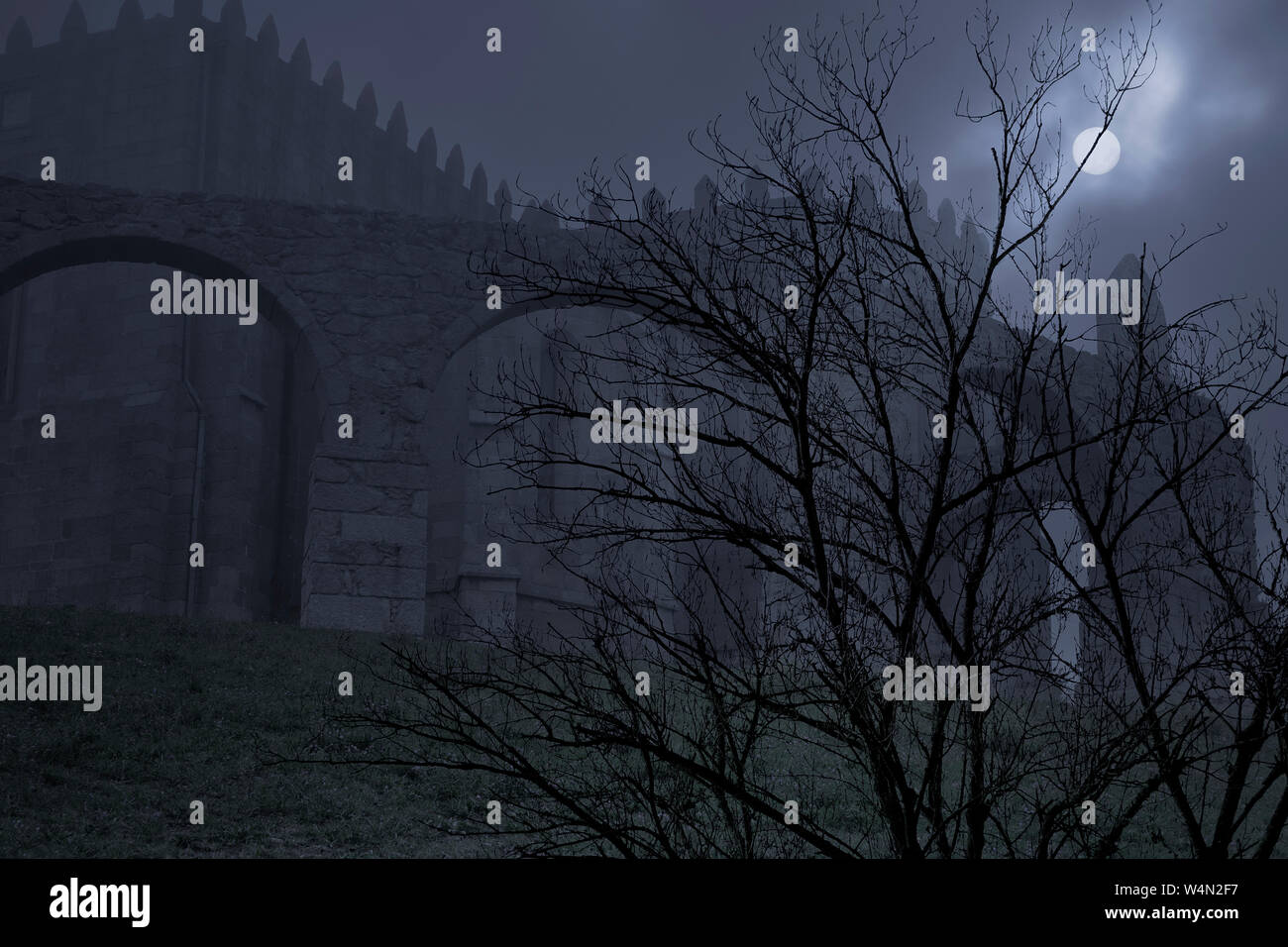 Ancien monastère médiéval dans un ciel couvert et brumeuse nuit de pleine lune Banque D'Images