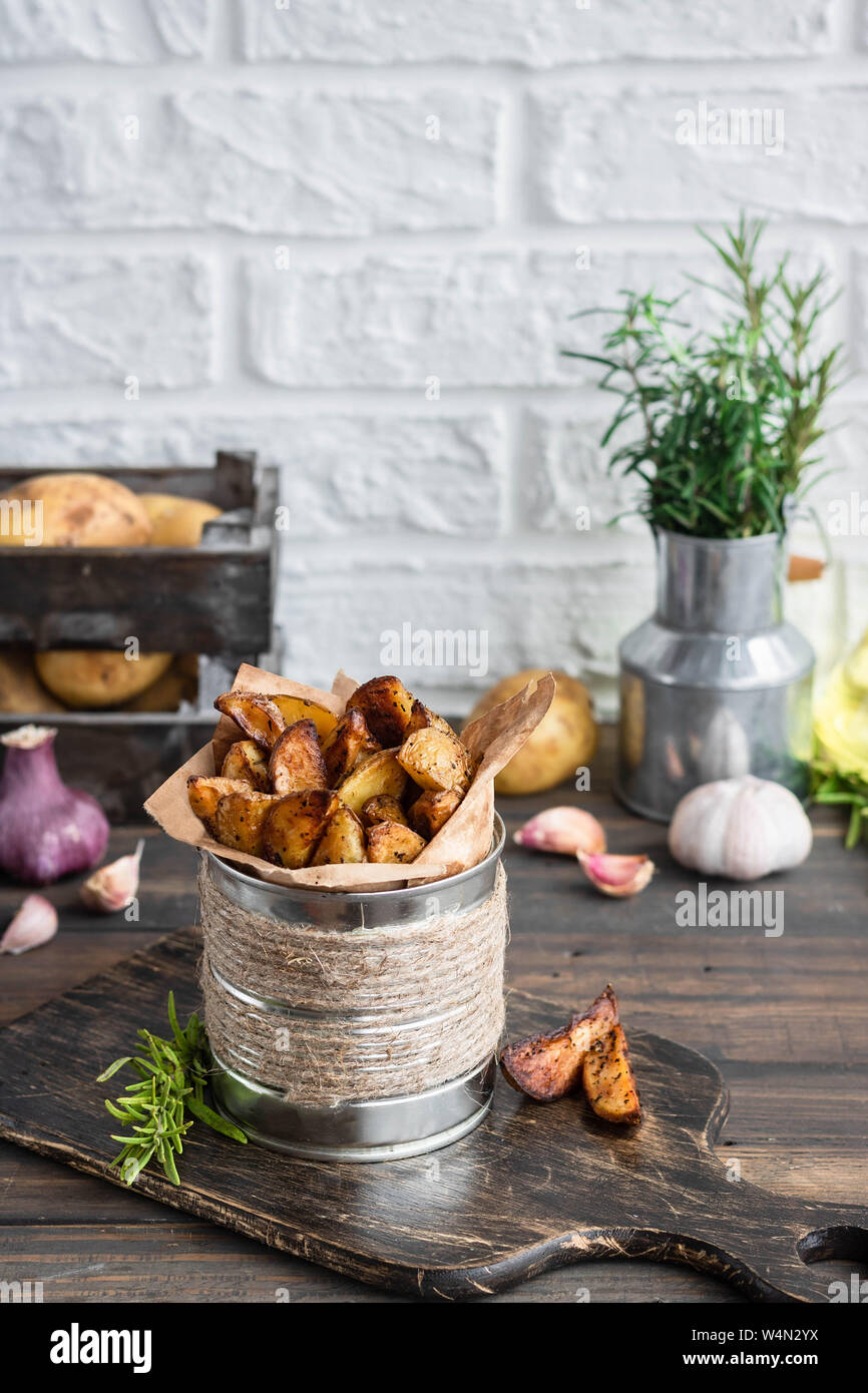 Les jeunes au four les pommes de terre dans un style rustique avec du romarin, l'ail et le sumac est un concept simple et de la nourriture délicieuse et une alternative aux frites. Banque D'Images