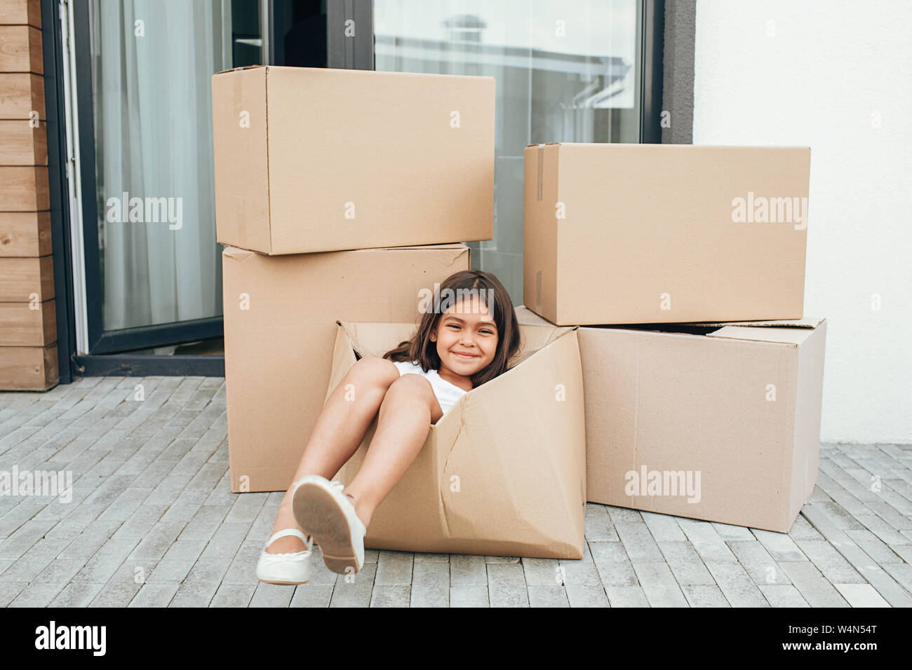 Petite fille jouant avec boîte en carton à l'arrière-cour. déménagement en  nouvelle maison Photo Stock - Alamy