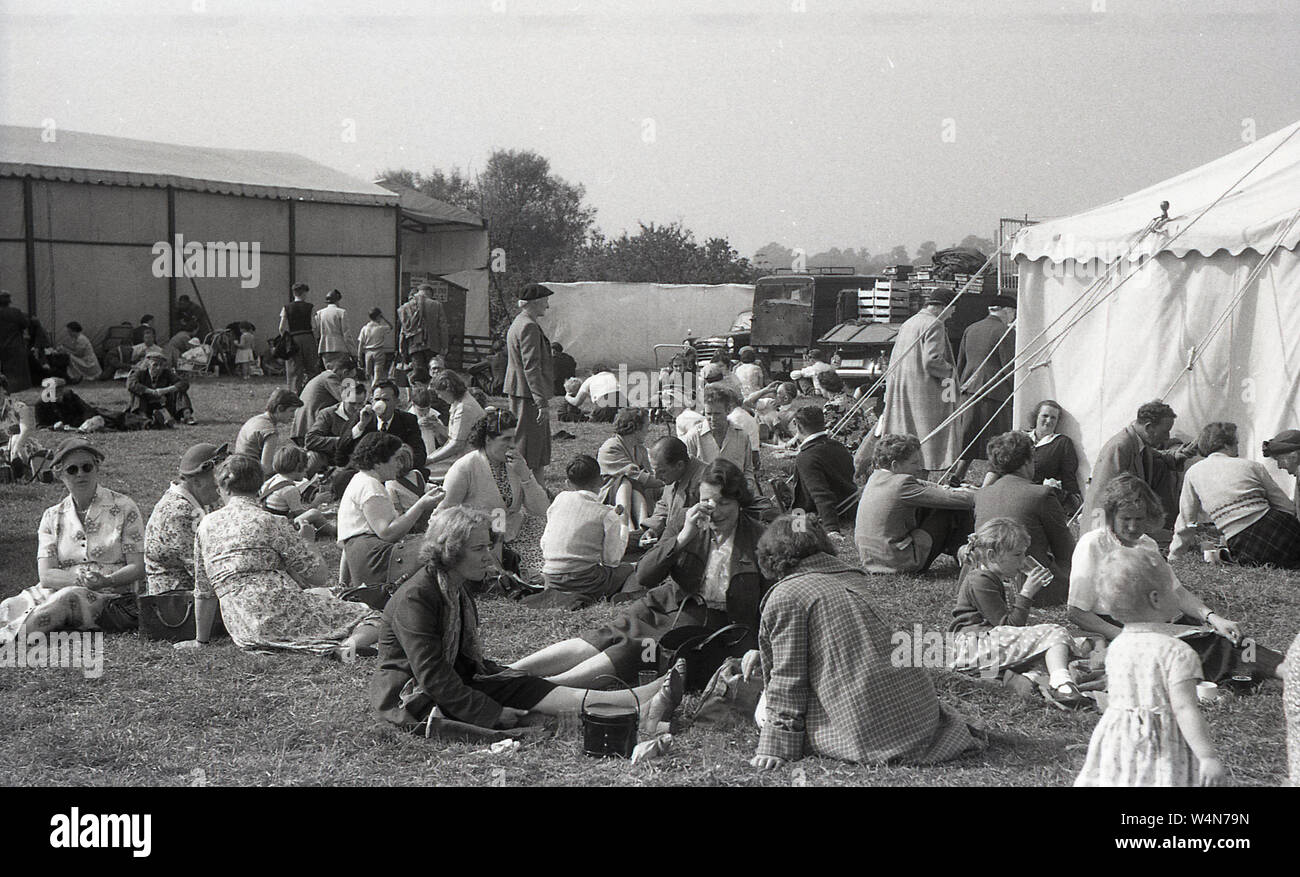 Années 1950, historique, à un pays, les visiteurs anglais juste vous détendre sur l'herbe à l'extérieur d'une tente, England, UK. Banque D'Images