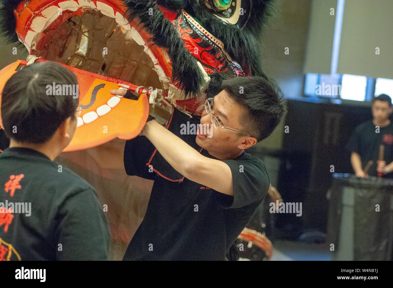 Tourné à l'épaule d'un artiste interprète ou exécutant la manipulation de la bouche d'un Lion Chinois costume, avec un batteur en arrière-plan, à l'Université Johns Hopkins University, Baltimore, Maryland, le 11 février 2006. À partir de la collection photographique de Homewood. () Banque D'Images
