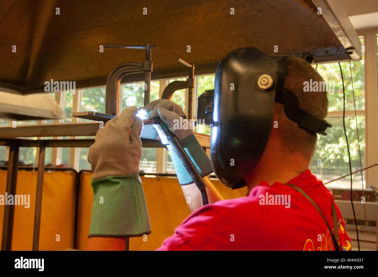 Profile close-up d'un soudeur, porter un casque de protection et des gants, travaillant dans un atelier de machines à la Johns Hopkins University, Baltimore, Maryland, le 2 octobre 2006. À partir de la collection photographique de Homewood. () Banque D'Images