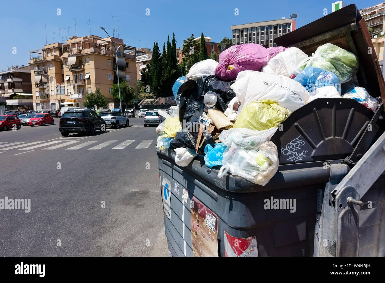 Corbeille pleine d'ordures devant des immeubles d'appartements en copropriété. Les poubelles poubelles débordent. L'incivilité, de l'impolitesse et de la saleté. Rome, Italie, Europe Banque D'Images