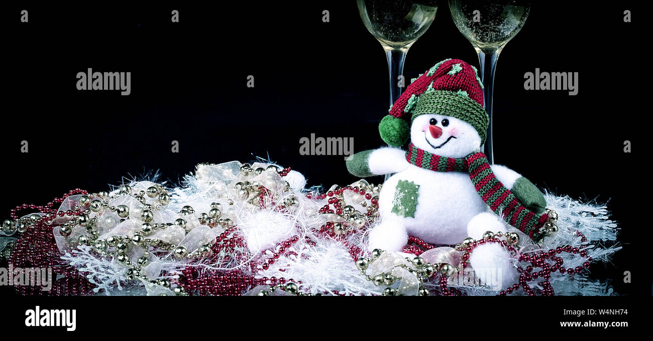 Fun toy snowman et deux verres de champagne sur un fond noir.photo with copy space Banque D'Images