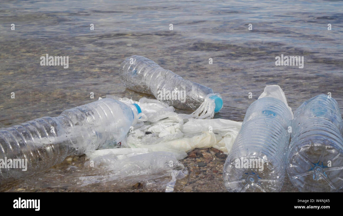 Les bouteilles en plastique sale sur la plage en pierre. La pollution de l'environnement. Banque D'Images