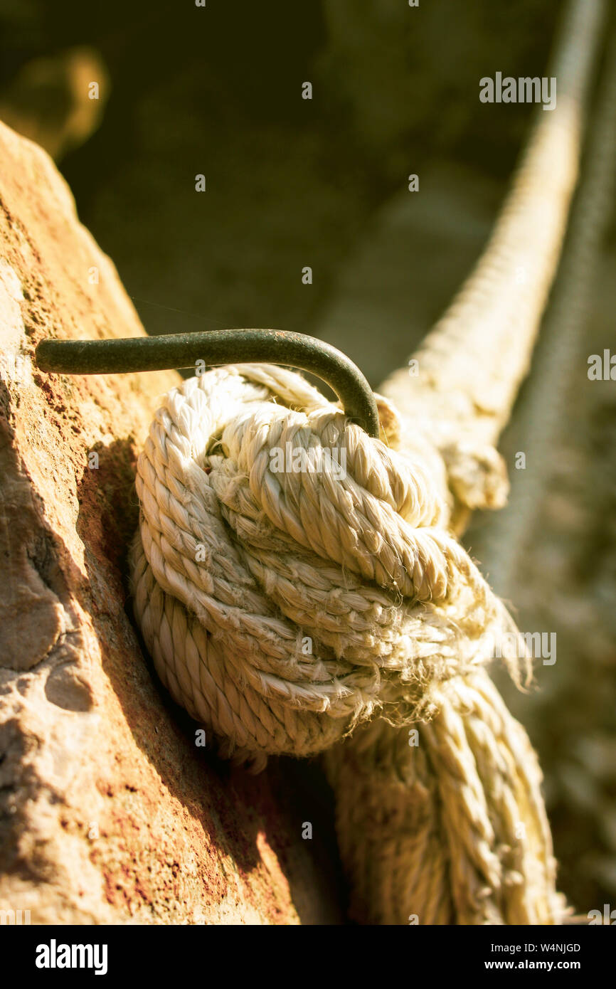 Cordon de tiques ou d'une corde peut-être de grand navire ou bateau amarré sur le crochet d'acier s'est lancé dans la pierre Banque D'Images