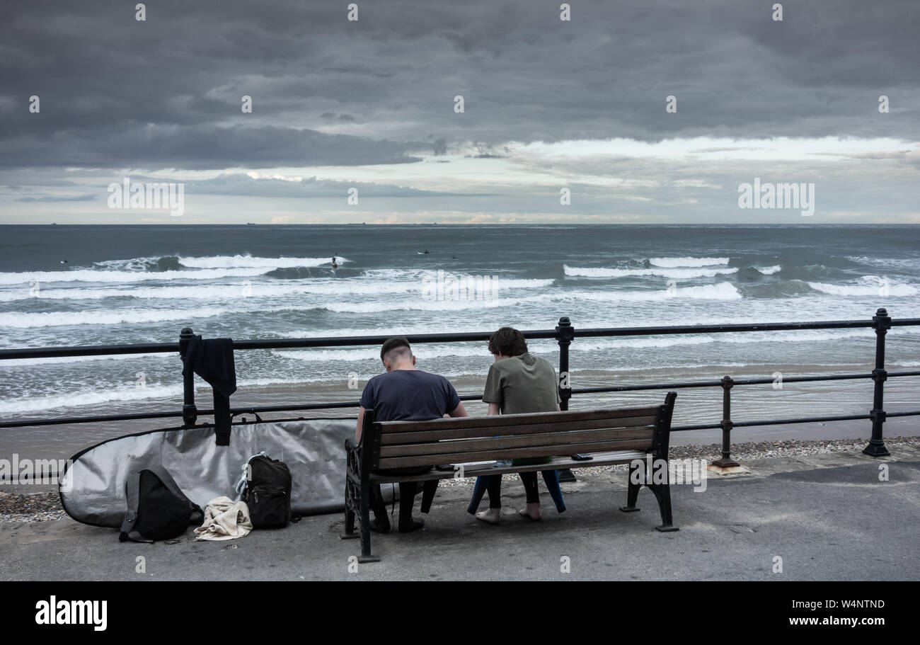 La consommation de poisson et les surfeurs de jetons à Saltburn by the sea, North Yorkshire, Angleterre. UK Banque D'Images