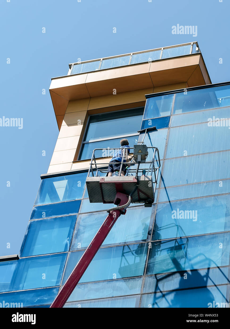 Homme Avec Mop Lave Facade En Verre Bleu De Autotower Ou Plate Forme De Travail Aerien Sur Une Journee Ensoleillee Les Gens Et La Vie En Ville Photo Stock Alamy