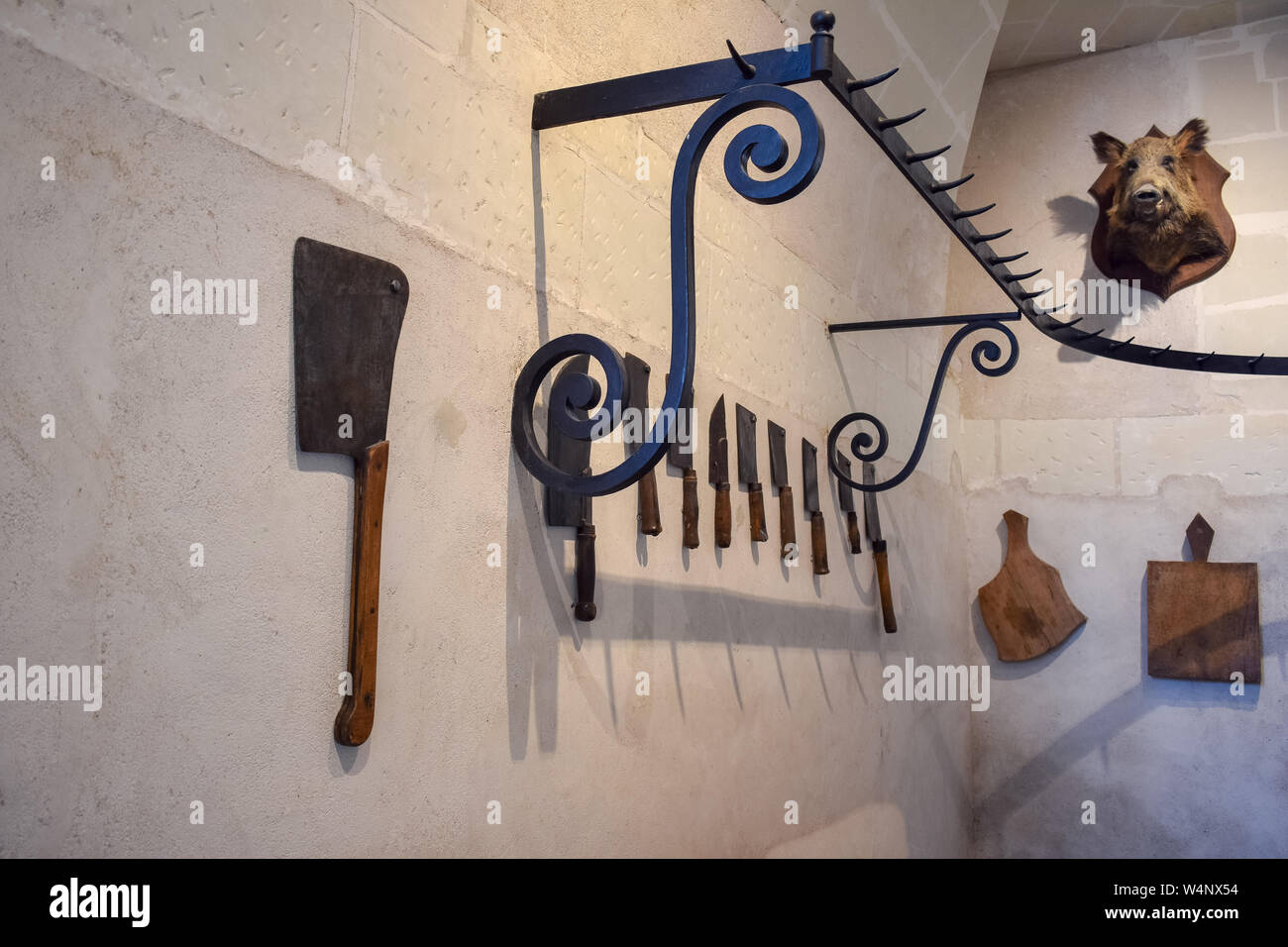 Les loisirs de l'ancien château du boucher. Couteaux et trophée de chasse avec la tête de sanglier, accrochées sur les murs. Banque D'Images