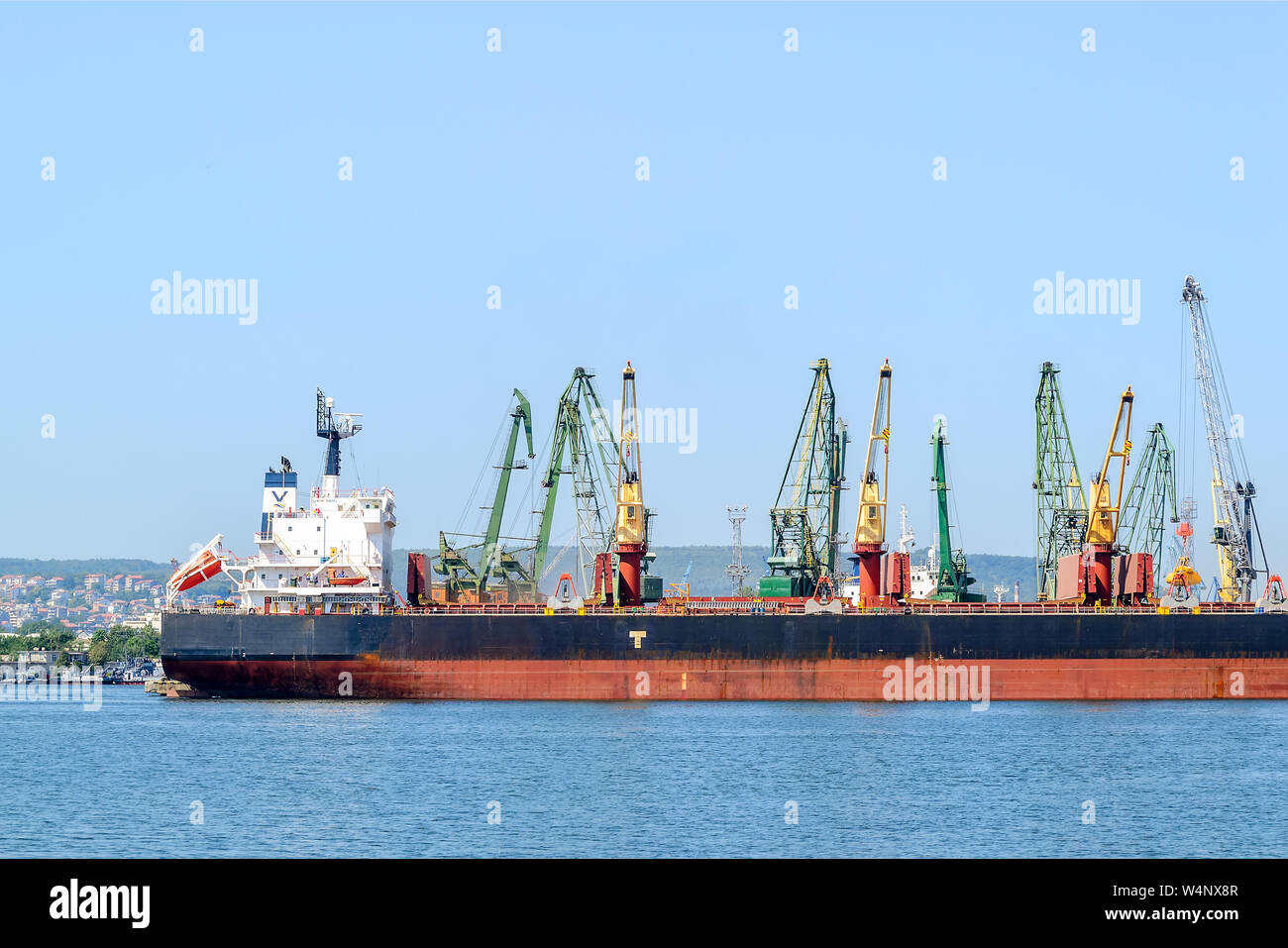 Varna, Bulgarie, le 22 juillet 2019. Grand cargo noir mer rouge tandis que le stationnement dans le port. Grues portuaires télécharger la cargaison dans le navire. Banque D'Images