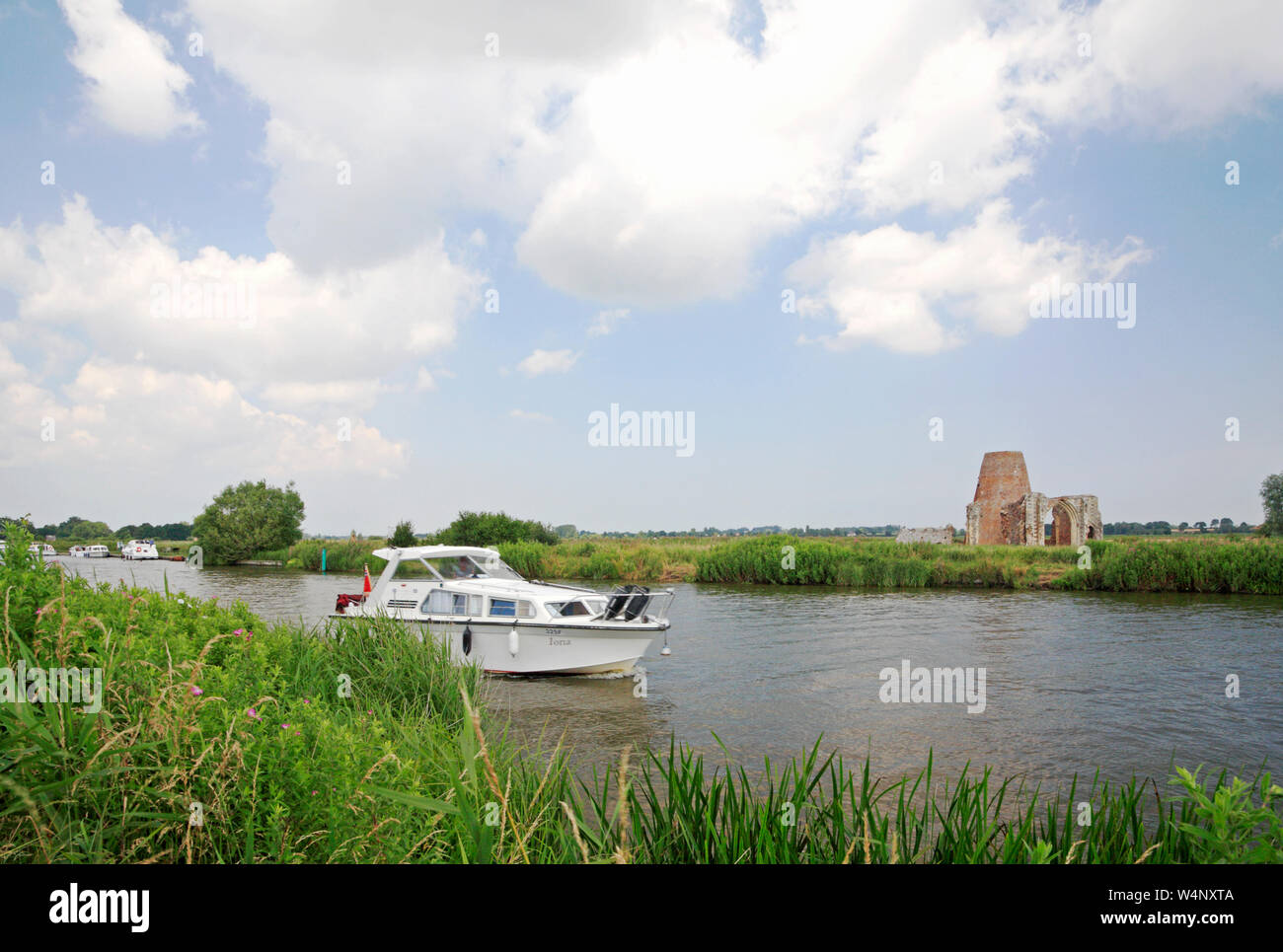 Un lancement en passant le St Benet's Abbey ruins sur la rivière Bure sur les Norfolk Broads à South Walsham, Norfolk, Angleterre, Royaume-Uni, Europe. Banque D'Images